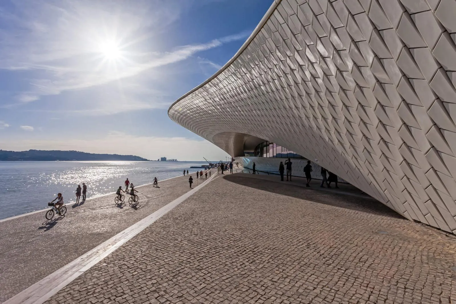 The MAAT museum on the Lisbon riverside, with people walking and cycling past.