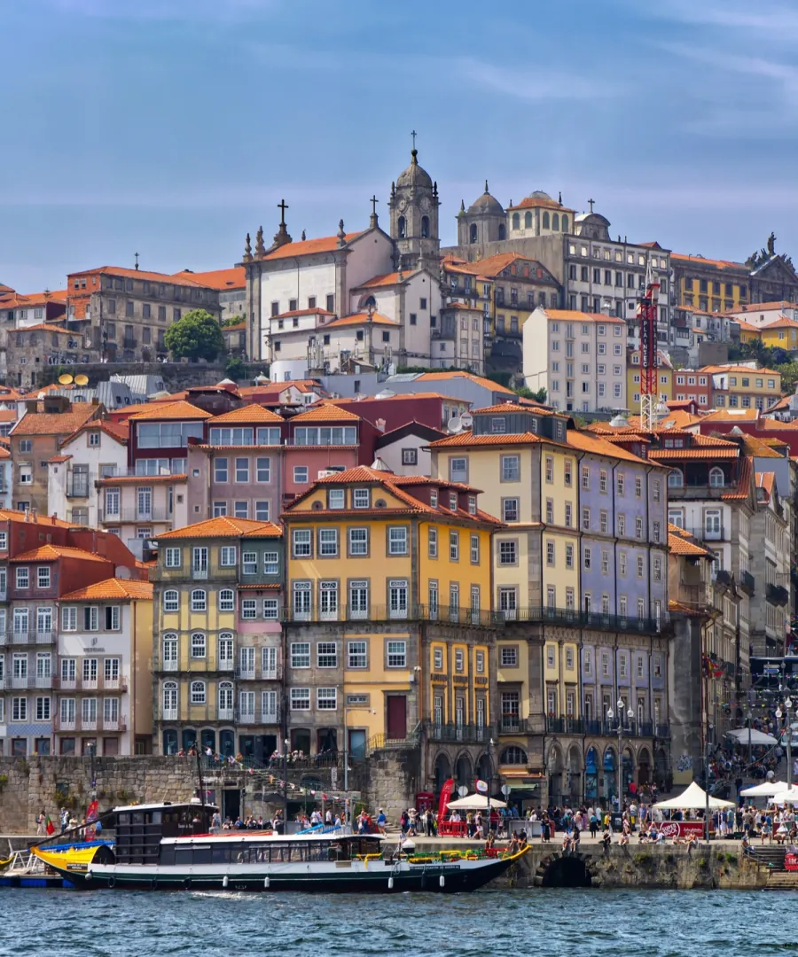 The Ribeira of Porto seen from the river, with rabelo boats moored.