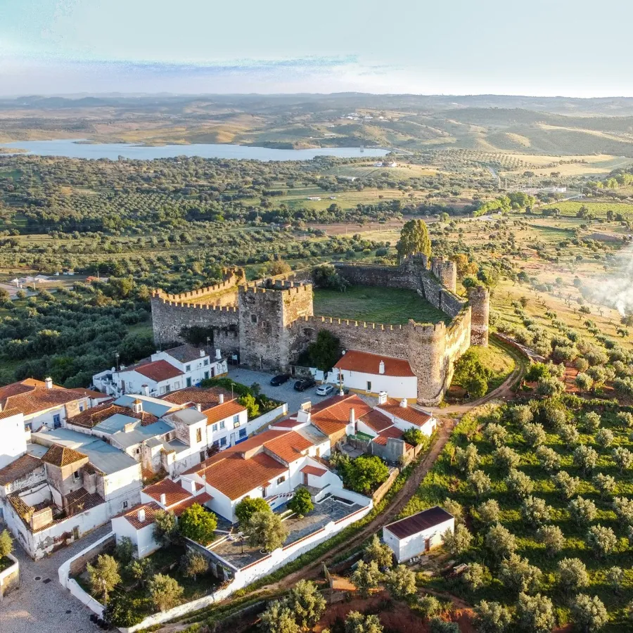 An Alentejo castle and village from the air, the reservoir behind.